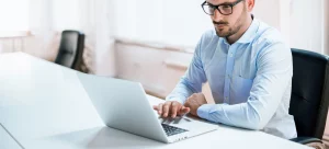 homme chemise bleue pc portable